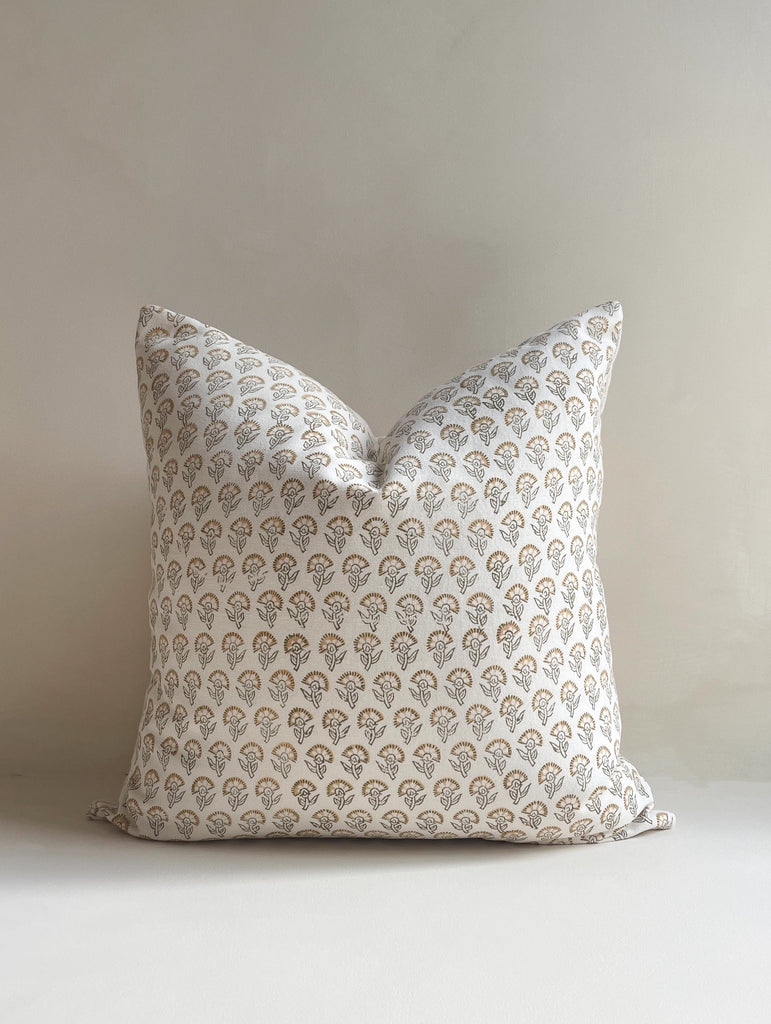 Front view of a 20x20” square luxury cotton Hand-woven cushion cover in a neutral tone featuring a tan floral pattern with a cotton back and invisible zipper. Displayed against a neutral limewash background, made in the United Kingdom